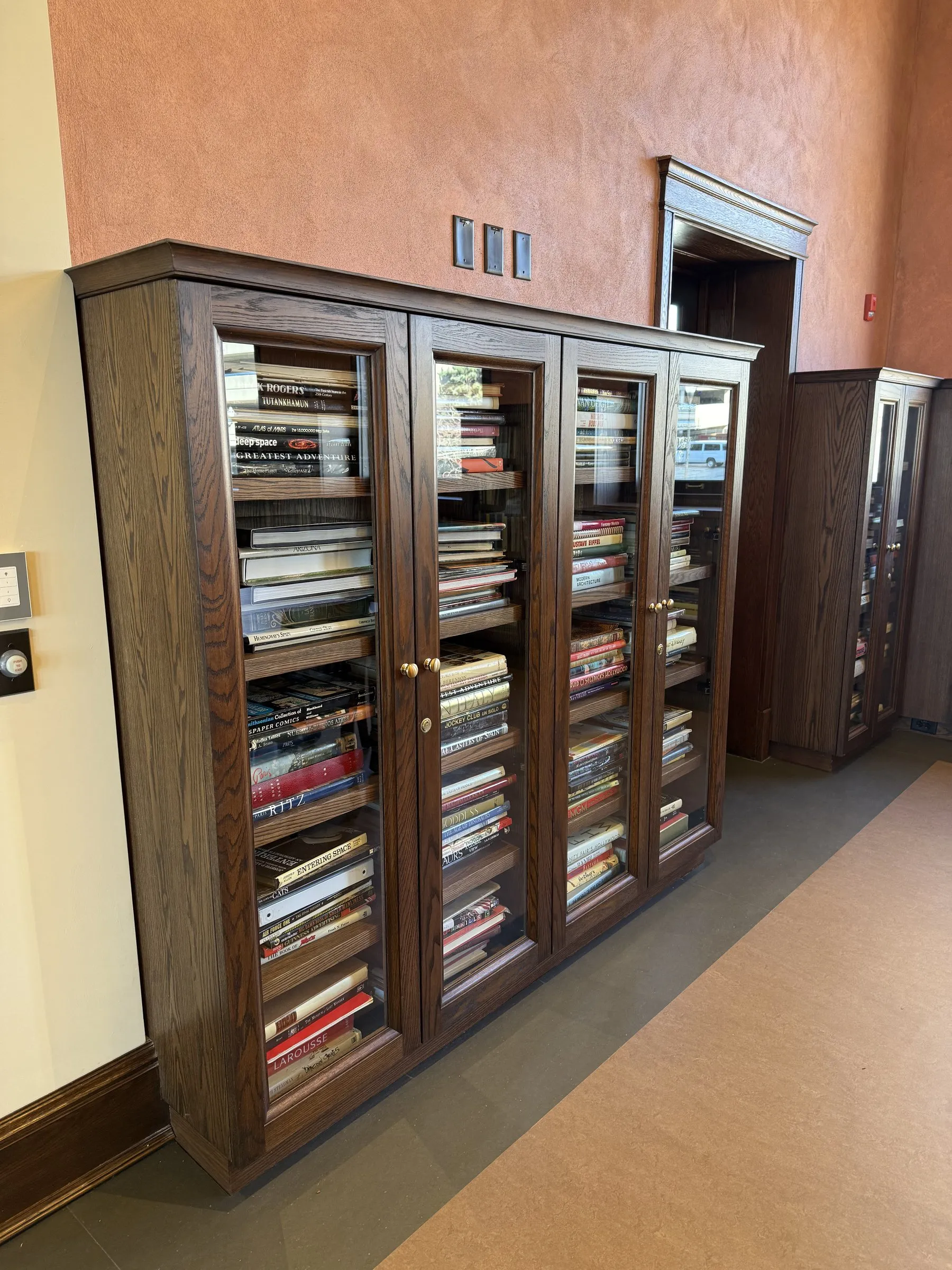 Floor-to-ceiling custom built-in bookcases with glass doors