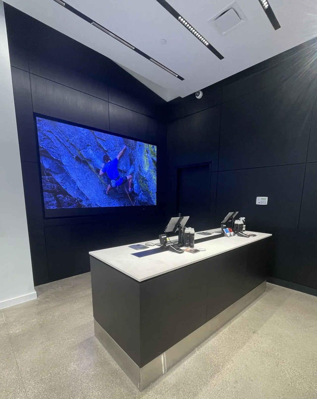 Sleek dark retail service island with a solid-surface top and integrated display