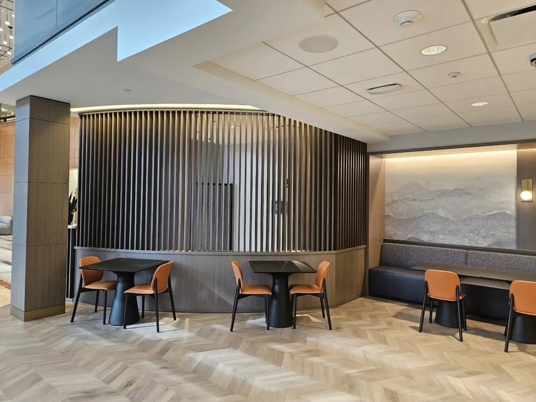 Curved wood slat feature wall in a corporate lounge with banquette seating
