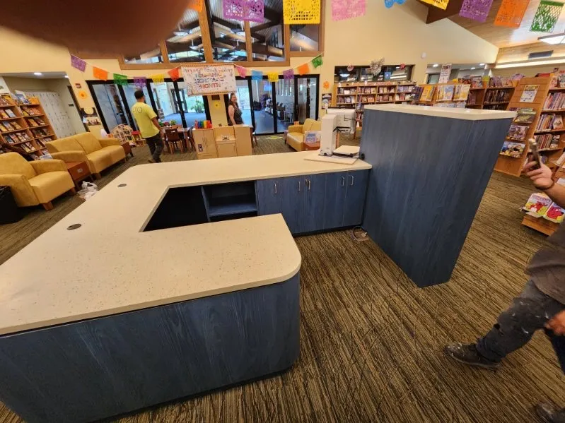 Library circulation desk with a speckled solid-surface top on blue-grey casework