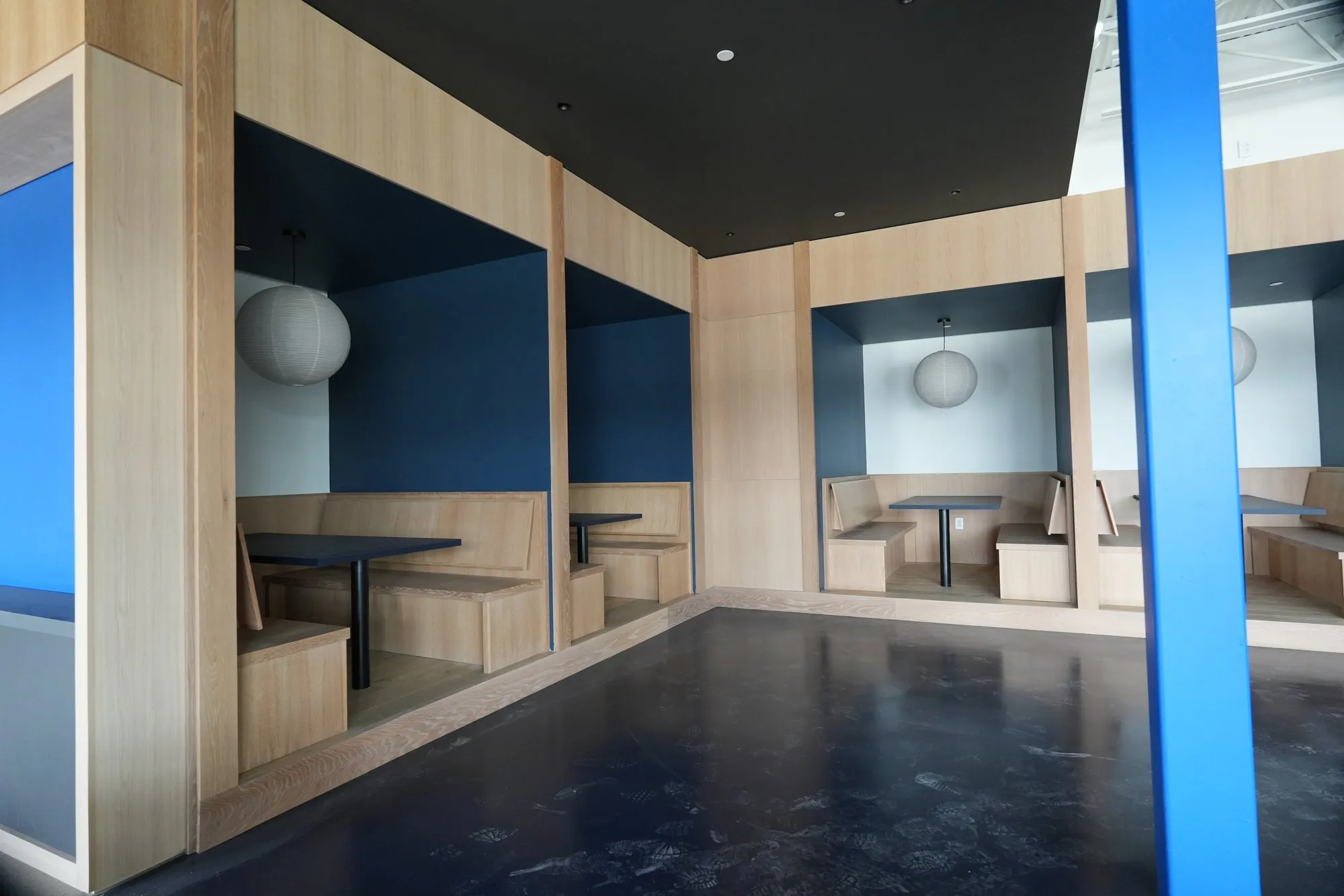 Custom white-oak booth millwork with built-in banquettes and paneled alcoves