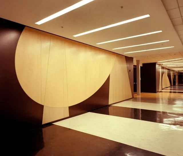 Curved light-wood plastic-laminate feature wall in a school corridor