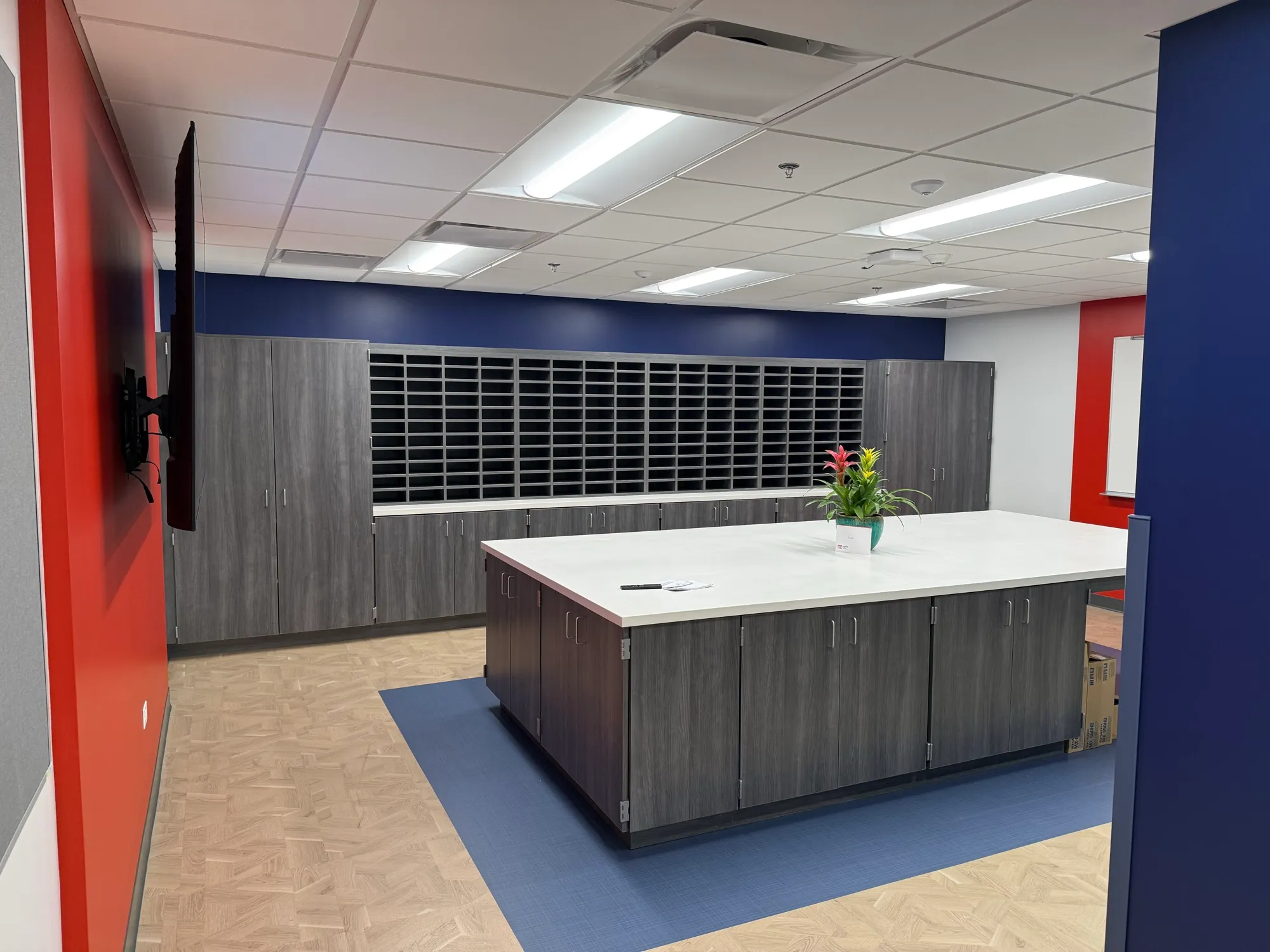 School faculty workroom with a solid-surface island and mail-sort casework