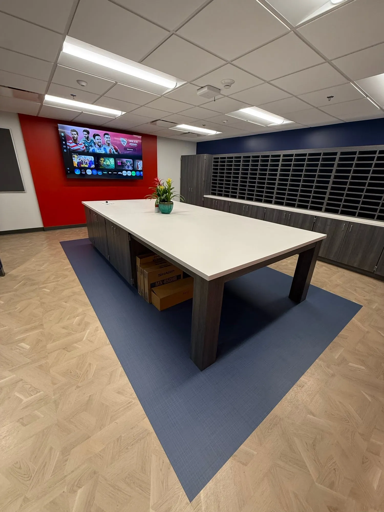 School faculty workroom with a solid-surface island, storage, and mail-sort casework